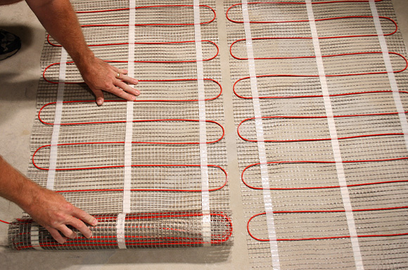 Radiant floor heating mats being installed.