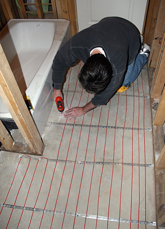 Installing heat cable for heated bathroom floor.